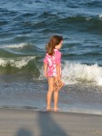 young girl at beach wearing a swim shirt for protection from the sun