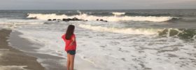 girl overlooking the waves at the beach