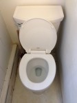 picture of a toilet with lid up in small bathroom
